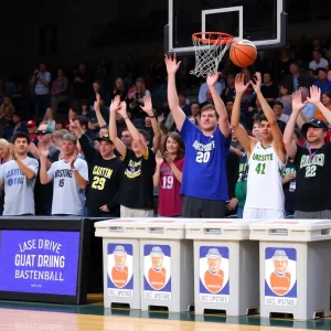 Fans cheering during the USC Upstate vs UNC Asheville basketball game with food drive collection bins.